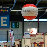 ballon hélium géant flottat au dessus d'un stand